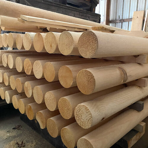 Stack of smooth, unfinished round logs at Estemerwalt Lumber Products, showcasing high-quality rustic lumber available for residential and commercial projects in Honesdale, PA.