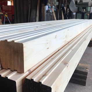 Precision-milled Eastern White Pine tongue and groove lumber boards in a rustic lumber yard setting, showcasing seamless installation for flooring and paneling projects.